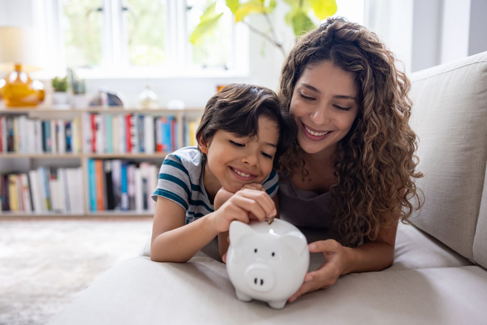 Mother and son saving money in a piggybank